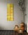A tall, narrow diptych in warm, weathered gold and olive tones, split by a strong vertical seam and traced with a faint...