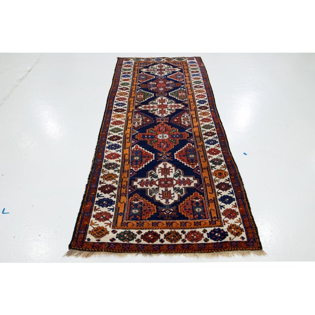 This blue Caucasian Vintage wool rug has an allover design with multicolor accents. This rug measures 3'8'' x 10'2''.