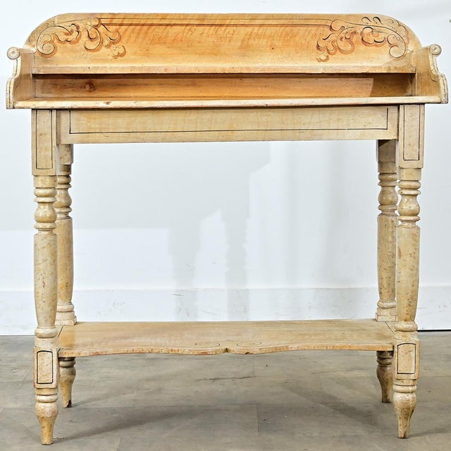 This 19th-century English vanity table is painted with a unique faux bois finish to imitate different kinds of maple. The...