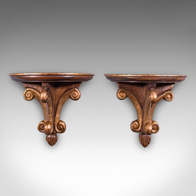This is a pair of vintage decorative wall brackets. An English, gilt painted mahogany clock or lamp shelf in Italianate...