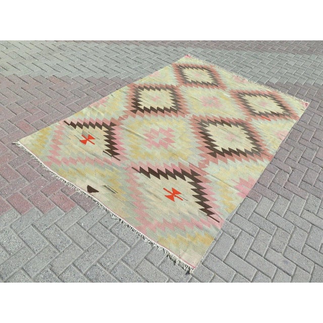 This beautiful, traditional vintage, flatweaved Turkish kilim rug is approximately 60 years old. It is handmade of very...