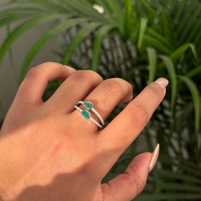 This open ring featuring a 0.67 carat pear cut natural emerald, set in 14K white gold. Each emerald measures approximately...