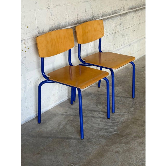 This set of two industrial stacking chairs features clean curved seats and supportive backrests. Their space-saving design...