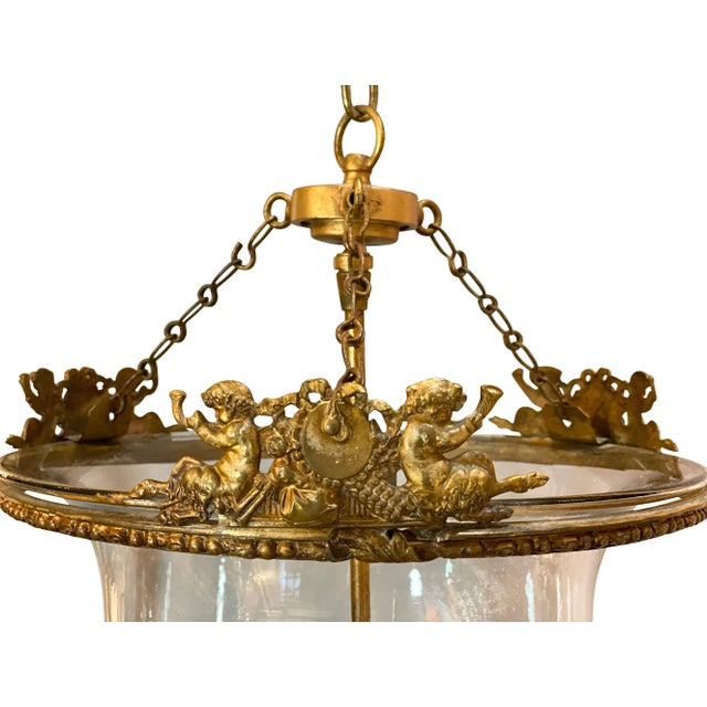 With eagle suspended clasping a ring and chain that suspends the glass jar suspended on three chains, the top gilt brass...
