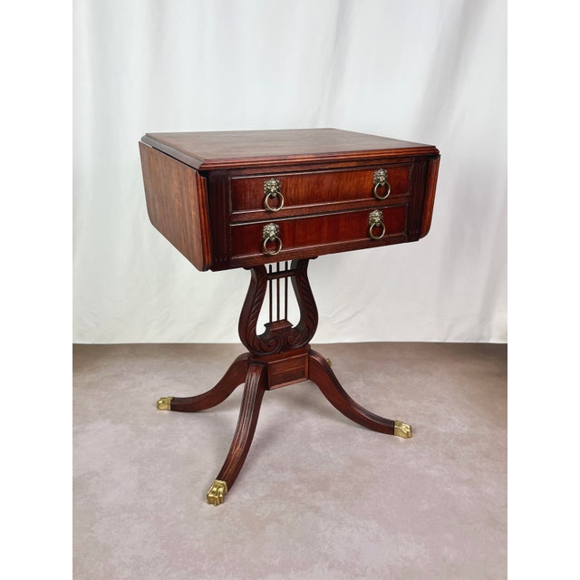 This elegant mid-century Duncan Phyfe Revival drop-leaf table combines classic Federal-style proportions with exceptional...