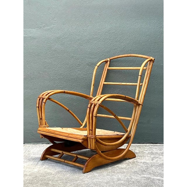 This vintage springer lounge chair is a sculptural study in bent rattan, with a tall, ladder-style back and sweeping,...