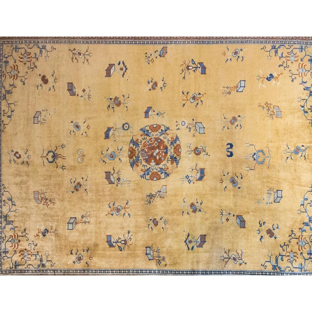 A rare and exquisite early 20th-century Chinese Peking rug, distinguished by its luminous gold fielda sought-after hue...