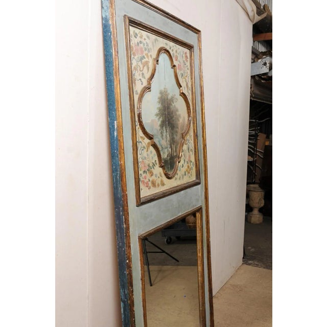 An Italian pier mirror with upper panel oil painting from the 19th century. This antique wall decoration from Italy...