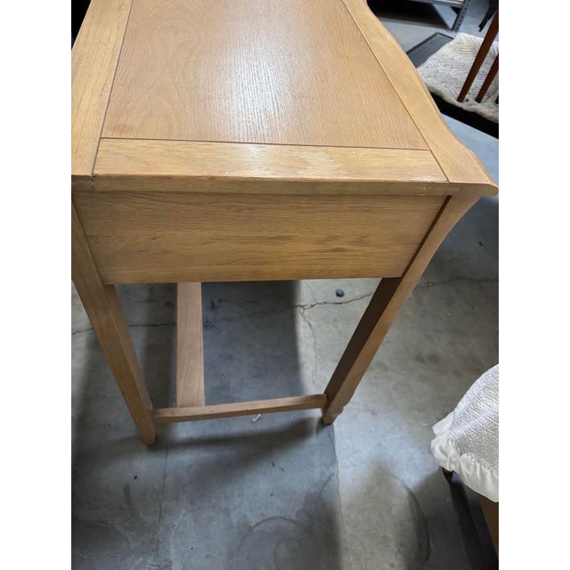 Charming vintage French Provincial writing desk and coordinating chair, featuring a warm light wood finish, and elegant...