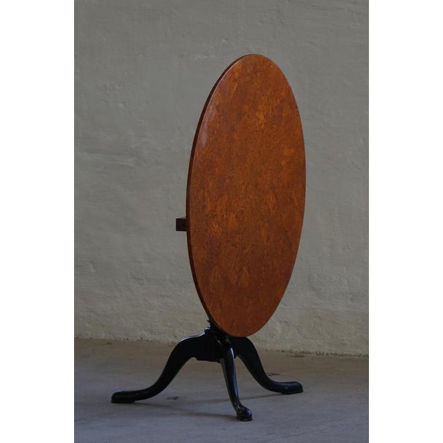 An elegant antique Swedish tilt-top occasional dining table crafted in richly figured burl wood veneer, dating to the...