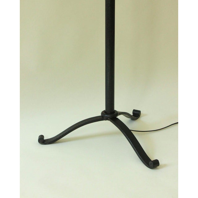 Large wrought iron floor lamp with a beautiful black patina, its tubular body adorned with four decorative reed-like...