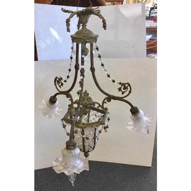 Beautiful Gothic style four light chandelier from the early 1900's. It is made of bronze with frosted glass flower light...
