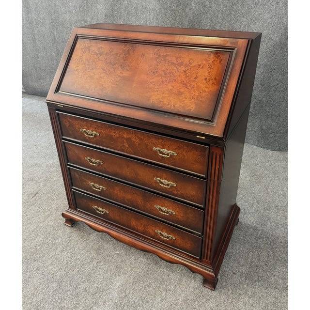 This Bombay Company secretary desk features a slant-front design with striking bookmatched burl veneers and decorative...