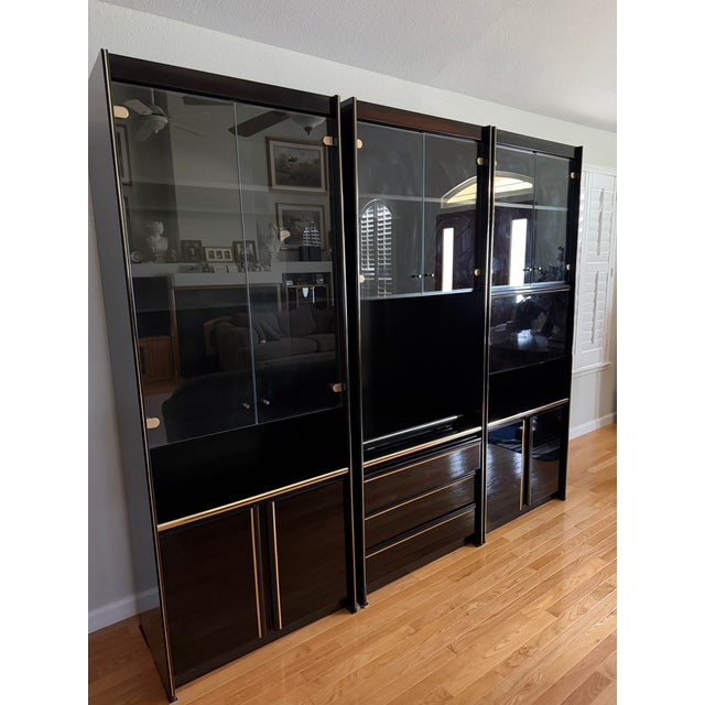 - German-made by Schieder Möbel in the 1980s - Black lacquer finish with glass doors and gold/brass accent hardware -...