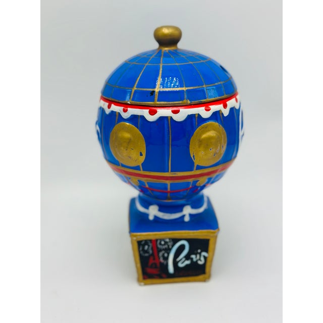 Charming vintage hand-painted ceramic Paris hot air balloon jar featuring a rich cobalt blue glaze with gilt accents,...
