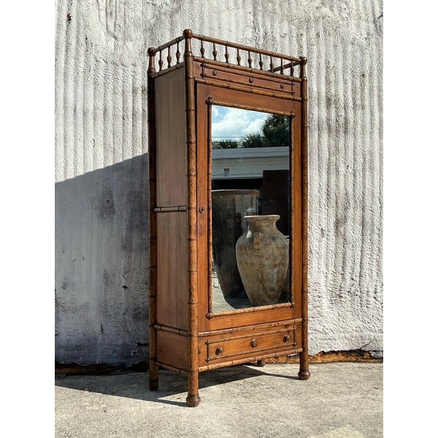 This vintage boho carved bamboo armoire combines intricate craftsmanship with natural materials, offering both style and...
