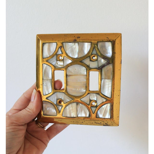 Vintage Hollywood Regency style double-toggle light switch plate cover. It features an ornate brass filigree grid inlaid...