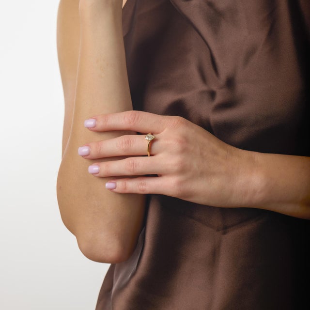 This timeless vintage engagement ring is a romantic expression of classic design, centered around the graceful silhouette...