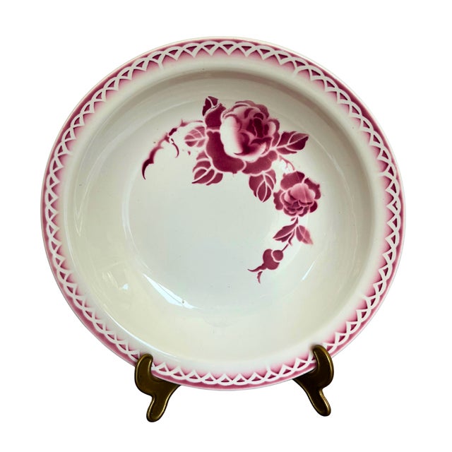 A large antique french serving bowl by sarreguemines, in the sought-after “josselin” pattern, decorated with a vivid red...