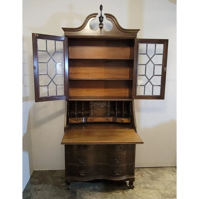 Circa 1920 mahogany slant top serpentine desk with glass bookcase top and original key. Made by North-Western Cabinet...