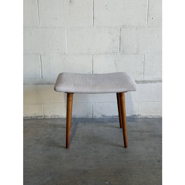 Vintage Danish Mid Century Modern vanity stool featuring solid teak tapered legs and a softly curved upholstered seat....