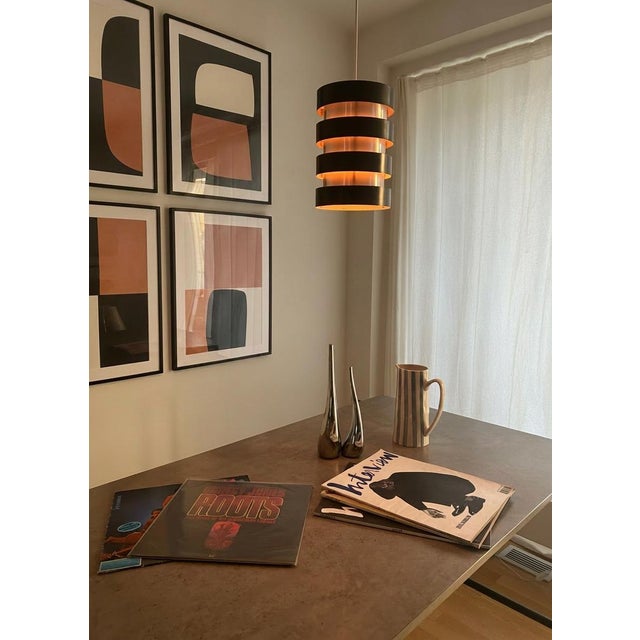 Alternating rings of brushed aluminium and lacquered black metal, stacked in a precise ascending sequence — when the...