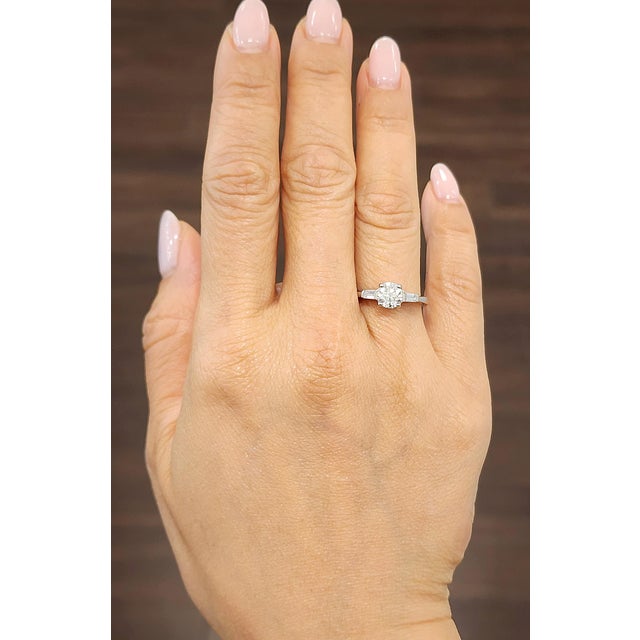 This gorgeous ring features a center diamond weighing 0.93 ct and two diamonds on the sides weighing 0.20 ct set in platinum.