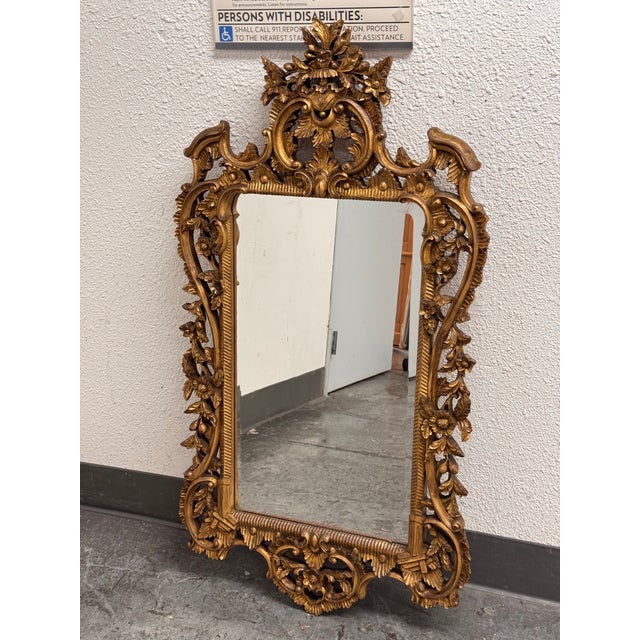 Design Plus Gallery presents an English Chippendale Carved Giltwood Mirror, Mid 20th Century. The mirror has a carved wood...