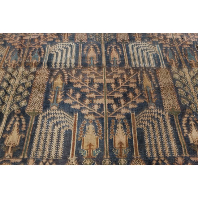 An early 20th century Persian Bakhtiari rug, the dark blue field with a highly-controlled garden design of lush weeping...