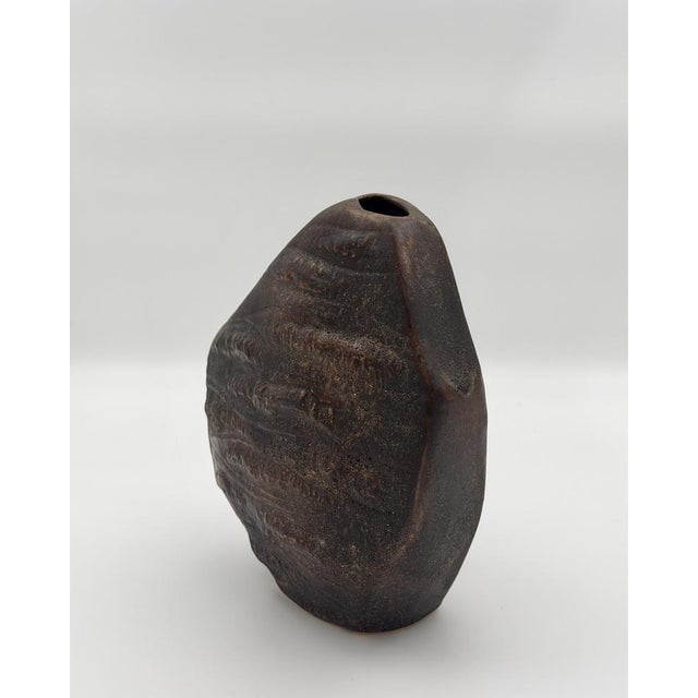 This striking studio ceramic vase features a highly tactile, sculptural silhouette that bridges the gap between functional...