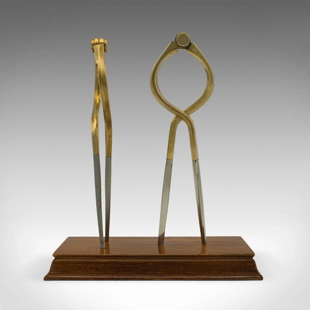 This is a vintage captain's dividers display ornament. An English, brass cartography navigation tool set upon mahogany...