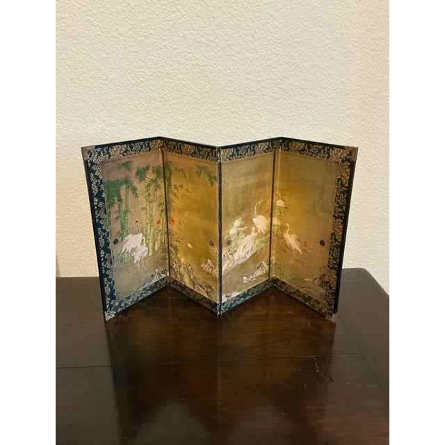 charming vintage four-panel tabletop folding screen featuring hand-painted Asian-inspired landscape scenes with elegant...