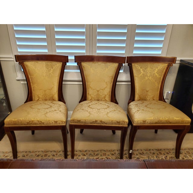 Elevate your dining space with this exceptional, showroom-quality set of eight (8) Neoclassical Regency style cherry...
