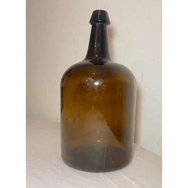 Up for sale is a large antique 19th century hand blown glass demijohn wine bottle. It's blown by hand out of thick green...