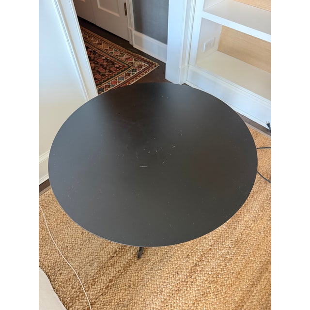 Industrial round blackened metal side table with tripod base. I’m not sure of the maker, as the item was purchased along...