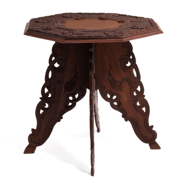 An octagonal Anglo Indian intricately carved hardwood folding table from the early 20th century. The top features...