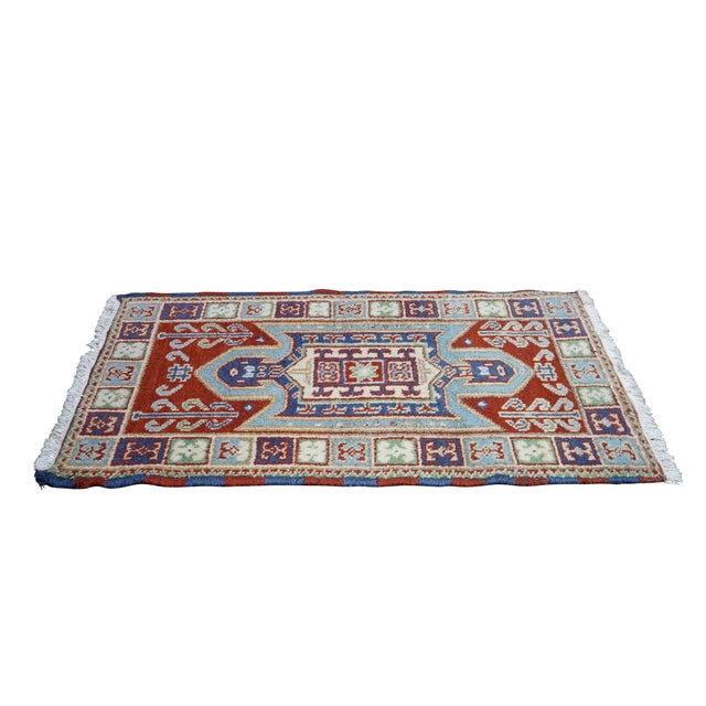 Vintage wool rug runner featuring a Oriental tribal pattern with central medallion and repeating border in red, green,...