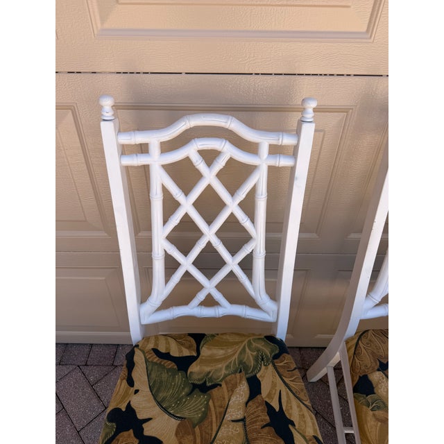 This Vintage set of four faux bamboo Chinoiserie dining chairs features a vintage Regency Chinese Chippendale style,...
