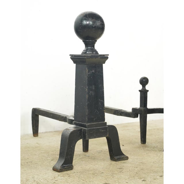 Antique andirons made of cast iron with cannonball style tops and a square column design. Andirons, also known as...
