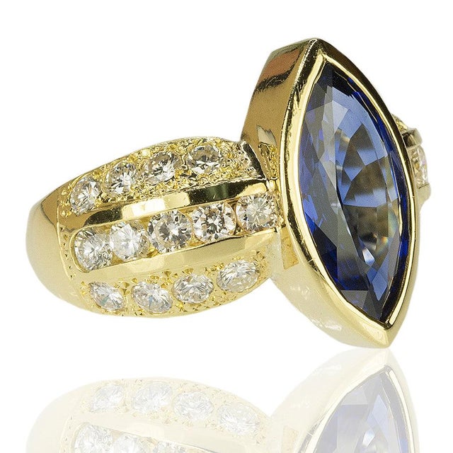 18k yellow gold ring with approximate 3.00 carat marquis shape sapphire and approximately 1.00 carat or round brilliant...