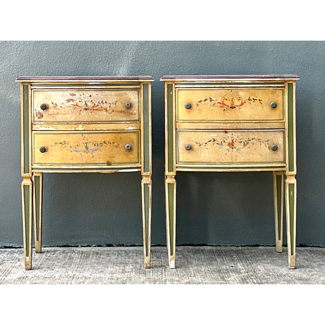This pair of vintage distressed hand-painted wood side tables brings practical storage and softly timeworn decorative...