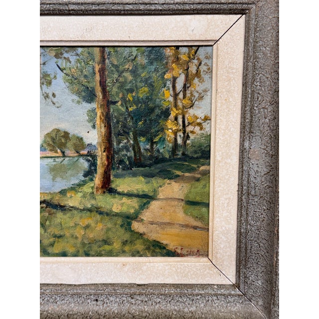 A lovely 20th century oil painting of a path beside a body of water on a lovely day. Bring the outdoors in with this...