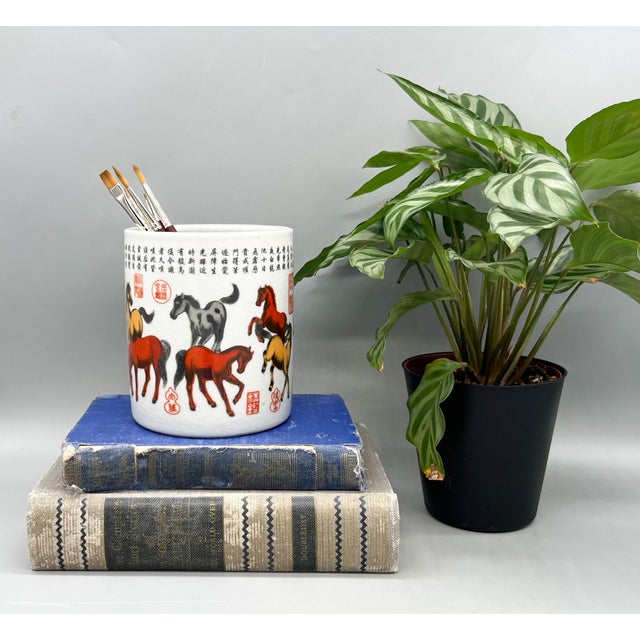Striking vintage Chinese porcelain brush pot featuring the classic “Eight Horses” motif, rendered in rich tones of red,...