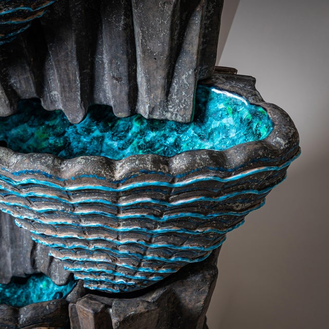 Decorative three-tier indoor fountain made of glazed ceramic in shades of gray and turquoise, likely produced in the San...