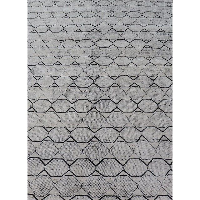 Measures 6'1 x 9'2 This modern Indian rug features no border on a black blended field with a simple geometric design lined...