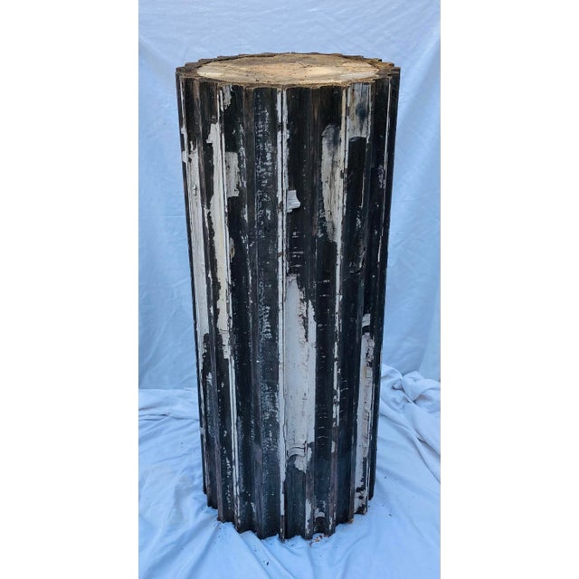 Vintage neoclassical fluted wood column peeling white paint