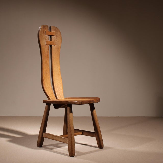 Exceptional set of 4 heavy, brutalist dining chairs made of solid oak, crafted in Belgium. The striking design features a...
