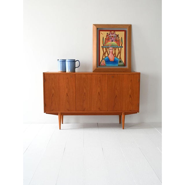 Vintage three-door teak cabinet with internal shelves and drawers. Simple, elegant, and functional lines. Scandinavian...