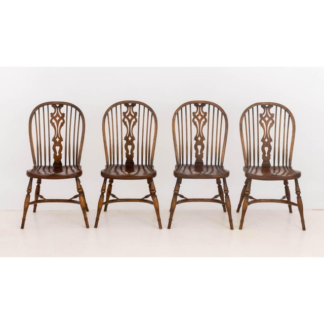Set of Seven Windsor Style Oak Side Chairs, with spindle backs on turned wood legs conjoined by H-form stretcher. 39" H x...