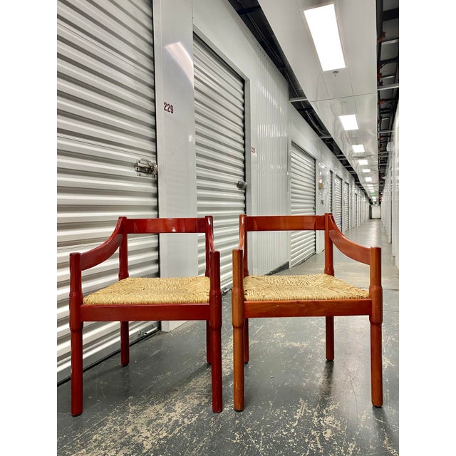 A pair of "Carimate" armchairs in lacquered beech, designed by Vico Magistretti. Vico Magistretti (1920 - 2006) was an...